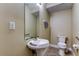 Bright half-bathroom with pedestal sink, commode, and neutral decor at 263 Alexander Woods Dr, Plant City, FL 33563