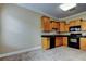Cozy kitchen featuring wood cabinets, black appliances, and stylish tile flooring at 263 Alexander Woods Dr, Plant City, FL 33563
