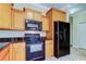Functional kitchen featuring wood cabinets, black appliances, and granite countertops for a sleek and modern look at 263 Alexander Woods Dr, Plant City, FL 33563