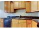 Kitchen featuring wooden cabinets, granite countertops, and modern black appliances at 263 Alexander Woods Dr, Plant City, FL 33563