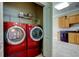 Convenient laundry room featuring red washer and dryer at 263 Alexander Woods Dr, Plant City, FL 33563