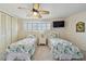 Bright bedroom featuring twin beds with ocean-themed quilts, plus shuttered windows and closet at 2970 68Th S Ave, St Petersburg, FL 33712