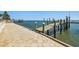 A view of a wooden dock and beige paver patio overlooking the bay and other waterfront properties at 2970 68Th S Ave, St Petersburg, FL 33712
