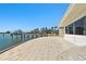 Waterfront home featuring a spacious patio with beige pavers and private dock with a boat in the background at 2970 68Th S Ave, St Petersburg, FL 33712