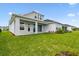 Spacious backyard with a covered patio area, lush lawn, and manicured landscaping at 31651 Westbury Estates Ave, Wesley Chapel, FL 33545