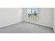 Bright, carpeted bedroom showcasing a large window with a street view at 31651 Westbury Estates Ave, Wesley Chapel, FL 33545