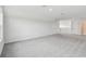 Large carpeted bonus room, featuring two entries, and a nice window at 31651 Westbury Estates Ave, Wesley Chapel, FL 33545