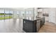 Modern kitchen featuring a large island with a sink, stainless steel dishwasher, and backyard access to the lake at 31651 Westbury Estates Ave, Wesley Chapel, FL 33545