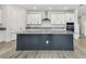 A modern kitchen with granite countertops, white cabinets, and stainless steel appliances with a large kitchen island at 31651 Westbury Estates Ave, Wesley Chapel, FL 33545