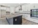 Spacious kitchen island with stainless steel appliances, granite countertops, and ample storage with white cabinets at 31651 Westbury Estates Ave, Wesley Chapel, FL 33545
