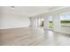 Spacious living room with sliding doors and windows, white walls, and wood-look flooring at 31651 Westbury Estates Ave, Wesley Chapel, FL 33545