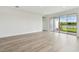 Bright living room with sliding doors and windows, white walls, and wood-look flooring at 31651 Westbury Estates Ave, Wesley Chapel, FL 33545