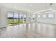 Spacious living room with natural light from many windows and wood-look flooring at 31651 Westbury Estates Ave, Wesley Chapel, FL 33545