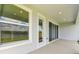 Covered patio with sliding glass doors, window, and views of the backyard and lake at 31651 Westbury Estates Ave, Wesley Chapel, FL 33545