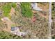 Aerial view revealing property lines, pool, and tennis court framed by lush greenery within a residential community at 33357 Westwood Dr, Ridge Manor, FL 33523
