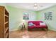 This bedroom features wood floors, a ceiling fan, and natural light from two windows at 33357 Westwood Dr, Ridge Manor, FL 33523