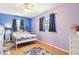 Well lit bedroom featuring laminate floors, ceiling fan, and two windows with curtains at 33357 Westwood Dr, Ridge Manor, FL 33523