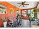 Orange sunroom with many windows, ceiling fan, seating, and exercise bike at 33357 Westwood Dr, Ridge Manor, FL 33523