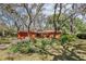 Charming single-story home with lush landscaping, mature trees, and a brick driveway at 33357 Westwood Dr, Ridge Manor, FL 33523