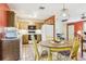 Cozy kitchen featuring tile flooring, wood cabinets, and a casual dining area at 33357 Westwood Dr, Ridge Manor, FL 33523