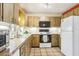 Functional kitchen featuring tile flooring, wooden cabinets, and a white refrigerator at 33357 Westwood Dr, Ridge Manor, FL 33523