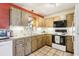 Well-lit kitchen featuring wooden cabinetry, tile flooring, and practical appliances at 33357 Westwood Dr, Ridge Manor, FL 33523