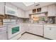 Bright kitchen with white appliances, tile backsplash, wine rack, and a window looking into another living area at 3610 Magnolia Ridge Cir # 1322/H, Palm Harbor, FL 34684