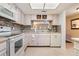 Bright kitchen with white appliances, tile backsplash, wine rack, and a window looking into another living area at 3610 Magnolia Ridge Cir # 1322/H, Palm Harbor, FL 34684