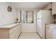 Bright kitchen with white cabinetry, a full-sized refrigerator, tile flooring, and a large window for ample natural light at 3610 Magnolia Ridge Cir # 1322/H, Palm Harbor, FL 34684