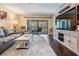 Inviting living room featuring hardwood floors, an entertainment center, a fan, and access to an outdoor balcony area at 3610 Magnolia Ridge Cir # 1322/H, Palm Harbor, FL 34684