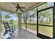 Relaxing screened-in patio with a ceiling fan and serene views of lush greenery at 367 Bobby Jones Rd # 367, Sarasota, FL 34232