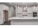 Bright kitchen featuring white cabinets, quartz countertops, stainless steel appliances, and stylish pendant lighting at 4787 Majestic Hills Loop, Brooksville, FL 34601