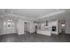 Spacious living area with gray wood flooring and a modern open-concept design to the kitchen at 4787 Majestic Hills Loop, Brooksville, FL 34601