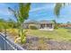 Lush backyard with tropical plants, a well-maintained lawn, and a cozy patio at 5409 Conch Shell Pl, Apollo Beach, FL 33572