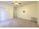Open bedroom features carpet, closet, ceiling fan, and door to ensuite bathroom, with a small display table at 5409 Conch Shell Pl, Apollo Beach, FL 33572