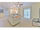 Bright living room with neutral tones, tile and carpet flooring, ceiling fan, and sliding glass doors to the outdoors at 5409 Conch Shell Pl, Apollo Beach, FL 33572