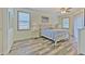 Serene main bedroom with wood-look floors, soft colors, two windows, and a ceiling fan at 5409 Conch Shell Pl, Apollo Beach, FL 33572