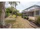 View of the home's backyard and screened-in patio area at 5664 Legend Hills Ln, Spring Hill, FL 34609