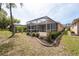 View of the home's backyard and screened-in patio area at 5664 Legend Hills Ln, Spring Hill, FL 34609