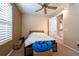 Bedroom with neutral colors, a ceiling fan, and an adjacent hallway at 5664 Legend Hills Ln, Spring Hill, FL 34609