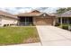Charming home with a two-car garage and well-maintained front yard at 5664 Legend Hills Ln, Spring Hill, FL 34609