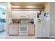 Functional kitchen features white appliances, tiled flooring, and ample cabinet space for storage at 5664 Legend Hills Ln, Spring Hill, FL 34609