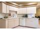 Well-lit kitchen with essential appliances, light wood cabinetry and tile flooring at 5664 Legend Hills Ln, Spring Hill, FL 34609