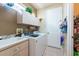 Well-organized laundry room with modern appliances, cabinets, and shelving at 5664 Legend Hills Ln, Spring Hill, FL 34609