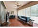 Comfortable living room with a cozy blue sofa, a fan, and large windows, creating a relaxing atmosphere at 5664 Legend Hills Ln, Spring Hill, FL 34609