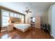 Bright bedroom with plantation shutters, a ceiling fan, and wooden floors, offering a comfortable retreat at 5664 Legend Hills Ln, Spring Hill, FL 34609
