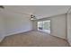 Carpeted bedroom with ceiling fan and sliding glass doors to outdoor balcony at 604 Mcdaniel St, Sun City Center, FL 33573
