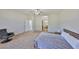 A neutral bedroom features a ceiling fan, carpet, sitting chair and a bathroom through an open doorway at 604 Mcdaniel St, Sun City Center, FL 33573