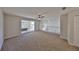 Second-floor loft area with ceiling fan, sliding glass door, and carpet floors at 604 Mcdaniel St, Sun City Center, FL 33573