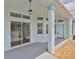 Covered patio with columns, decorative lighting, and a sliding glass door into the home at 604 Mcdaniel St, Sun City Center, FL 33573